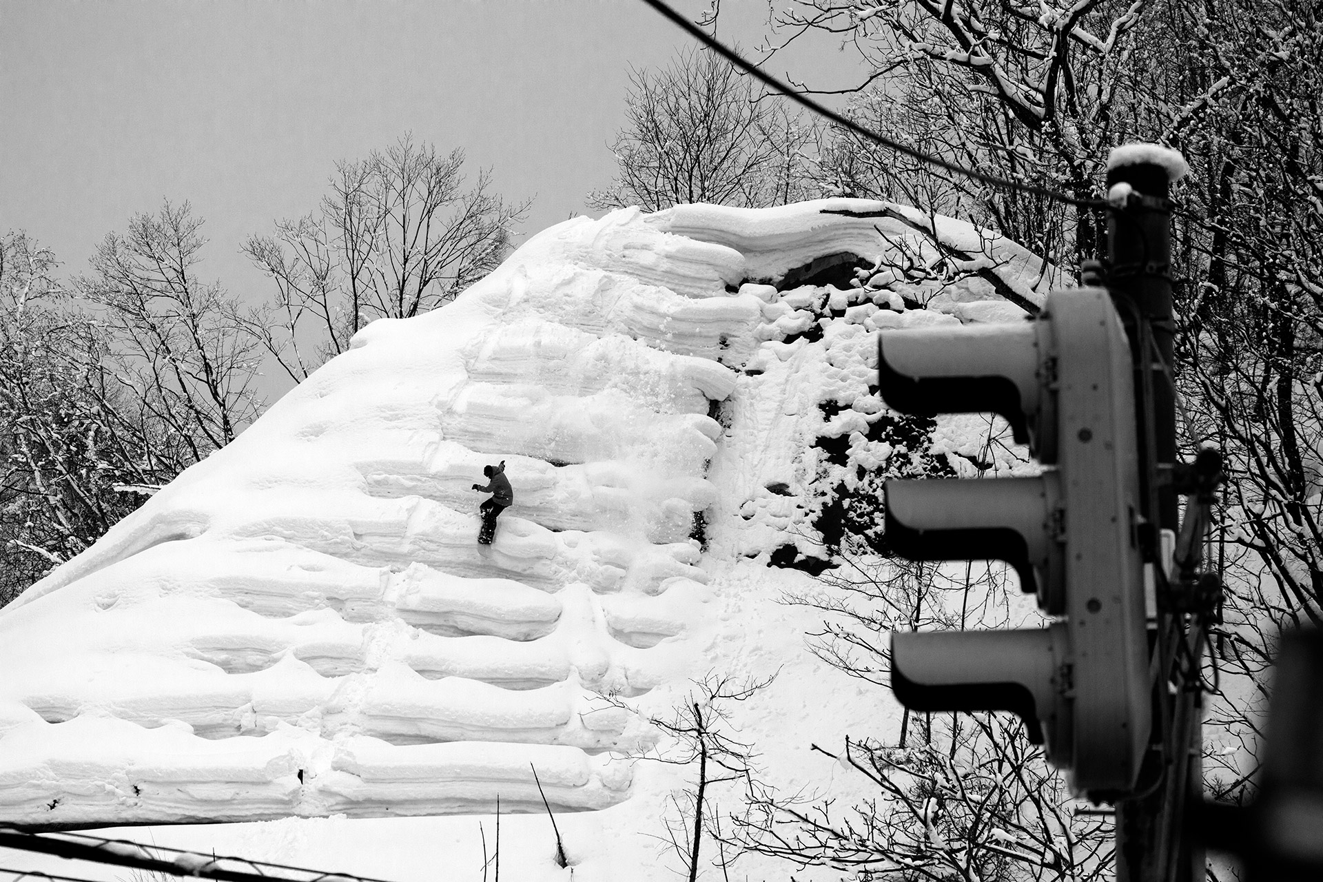 Riding a roadside snow bank past a traffic light