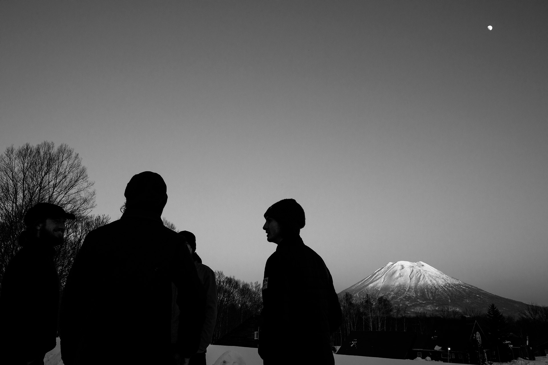 The crew at dusk under Mount Yōtei, moon overhead