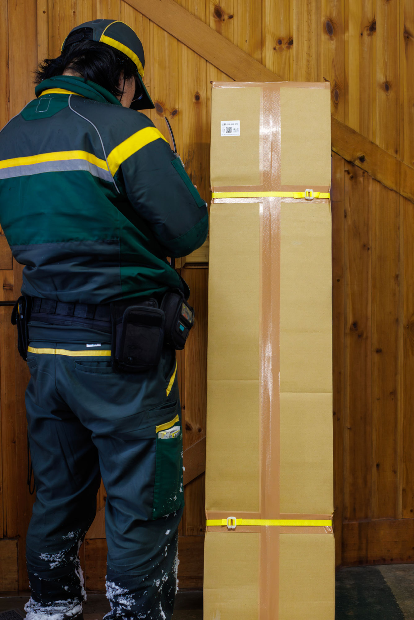 A courier with a boxed Offshore board, ready to leave the Niseko workshop