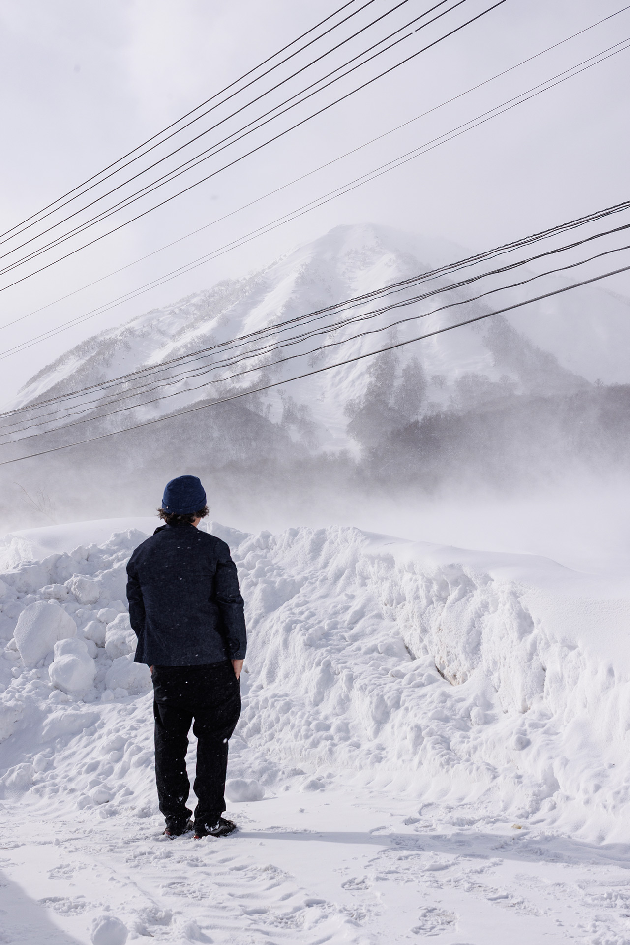 Josh looking out at the mountain in a storm, Niseko